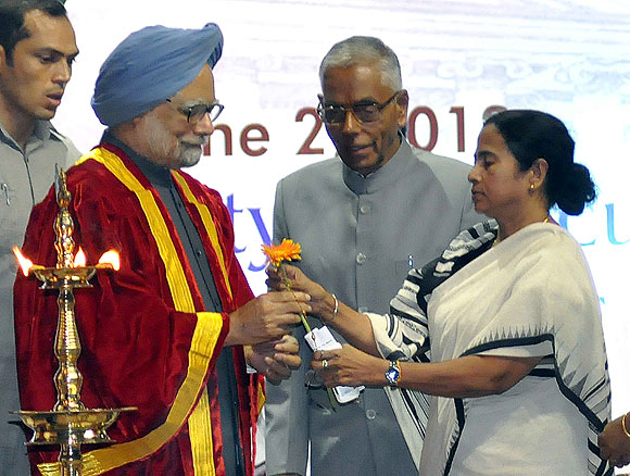 West Bengal Chief Minister gives a flower to Prime Minister Manmohan Singh as Governor M K Narayanan looks on at the Science Congress in Kolkata on Saturday