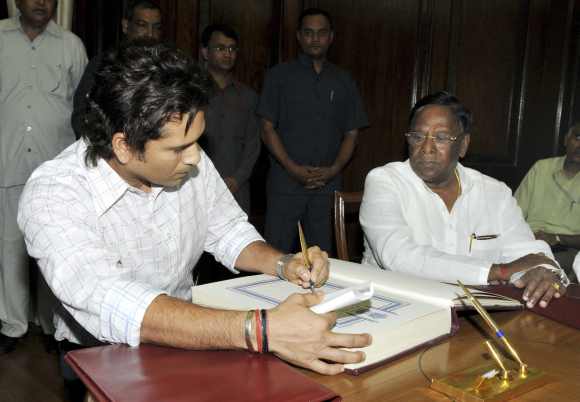 Sachin Tendulkar signs the oath book during the swearing-in ceremony at the Parliament