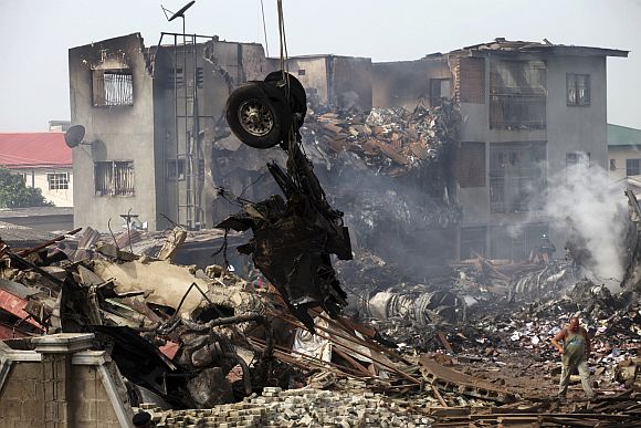 A crane lifts the tyres of a plane after it crashed at Iju-Ishaga neighbourhood in Lagos June 4, 2012
