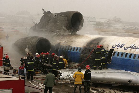 Firemen put out remnants of fire in a plane that caught fire while landing in Mashad, 924 km northwest of Tehran January 24, 2010