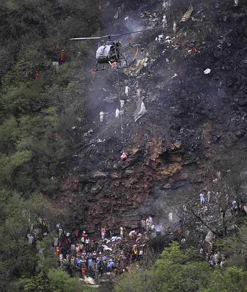 A helicopter airlifts a blood-stained sack containing the recovered bodies of victims from the wreckage of an Airblue passenger plane which crashed in Islamabad's Margalla Hills July 28, 2010