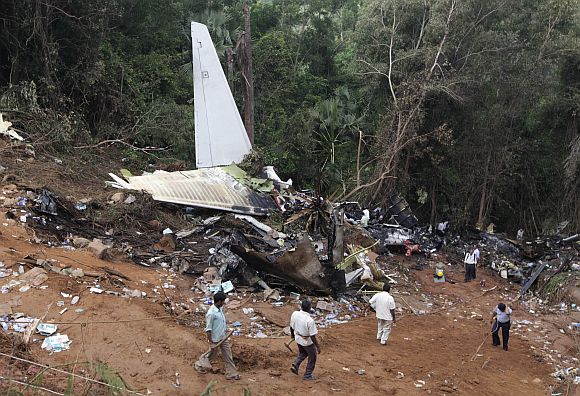 Forensic officials and rescue workers inspect the wreckage of a crashed Air India Express passenger plane in Mangalore May 23, 2010