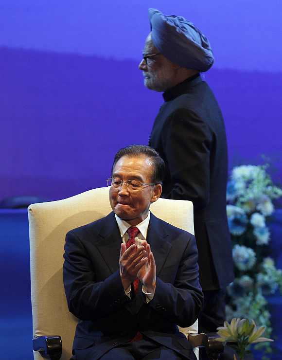 Chinese Premier Wen Jiabao applauds as Prime Minister Manmohan Singh walks to address the audience in New Delhi