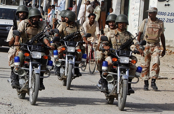 Paramilitary soldiers patrol a neighborhood on motorbikes during an operation