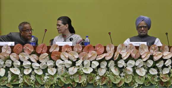 Finance Minister Mukherjee speaks with Congress chief  Sonia Gandhi as Prime Minister Manmohan Singh looks on during the CWC meeting at the parliament annexe in New Delhi