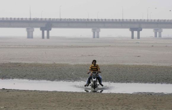 A man drives his motorcycle on the dry Chenab river in Pakistan, near the Gujarat border. The dispute over Chenab river has been a flashpoint between India and Pakistan.