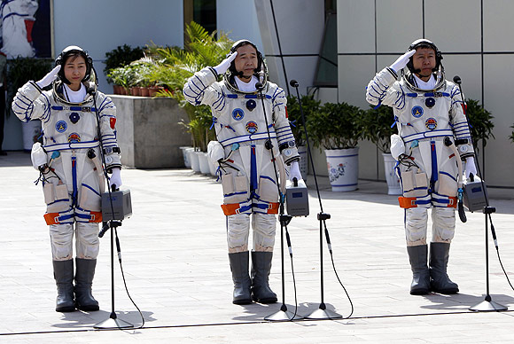 Chinese astronauts Jing Haipeng (Centre), Liu Wang ( Right) and Liu Yang salute during a departure ceremony at Jiuquan Satellite Launch Center, Gansu province
