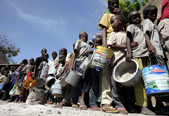 Internally displaced children queue to collect food relief from the World Food Programme  at a settlement in Mogadishu, Somalia