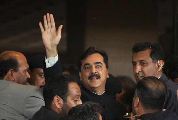 Pak PM Gilani waves to supporters as he arrives at the supreme court in Islamabad on April 26