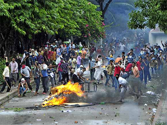 Garment workers throw pieces of bricks during clashes with police in Kanchpur, Dhaka