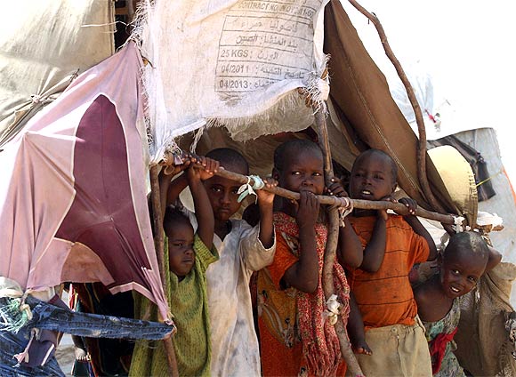 Internally displaced children stand inside their makeshift shelter at a camp in the Hodan district of Somalia's capital Mogadishu