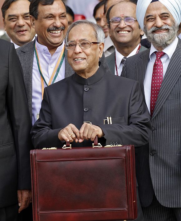 Finance Minister Mukherjee smiles as he leaves his office to present the 2012/13 budget in New Delhi