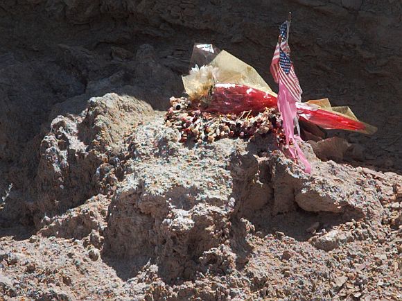A portion of the site where a UFO allegedly crashed near Roswell in 1947 is marked with flowers and two small US flags.