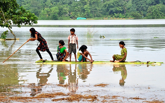 Flood affected children are seen using a boat made out of banana leaves in Morigoan district, about 80 Km from Guwahati