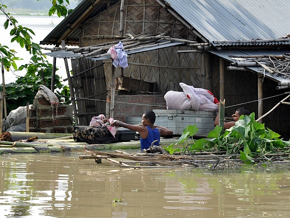 A man tries to salvage his belongings from his flood ravaged home
