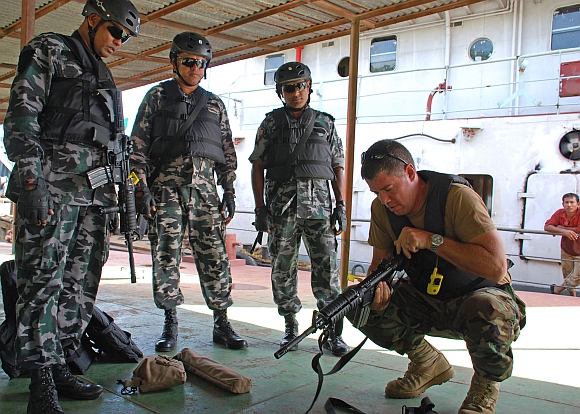 A US soldier does follow-up clearance checks on Bangladesh Navy sailors' weapons