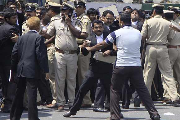 Police try to control a violent lawyer outside the court premises in Bengaluru