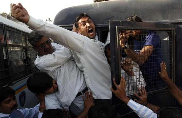 A survivor of the Godhra riot shouts anti-government slogans as he is detained by police during a protest to commemorate its 10th anniversary in Ahmedabad