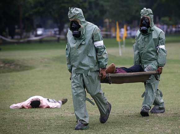 Soldiers carry a man acting as an injury victim on a stretcher during an exercise to prepare for chemical and biological terror attacks