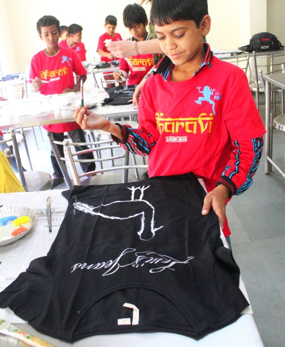 Underprivileged children from Mumbai paint a T-shirt as part of the 1000 Crane Project