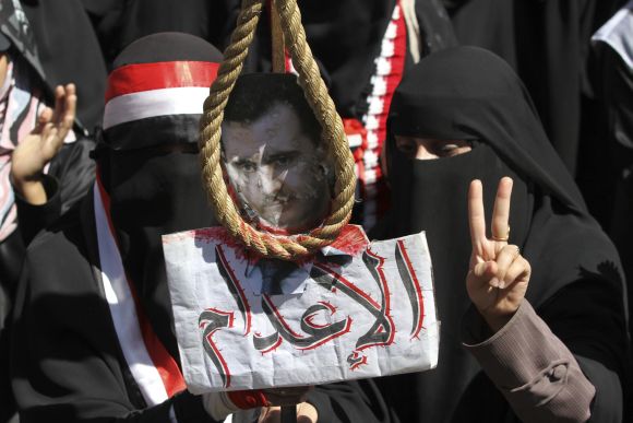 Anti-government protestors hold a picture of Syrian President Assad with a noose