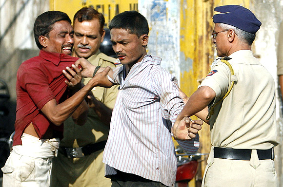 Policemen break up a quarrel between migrant workers at a street corner in Mumbai