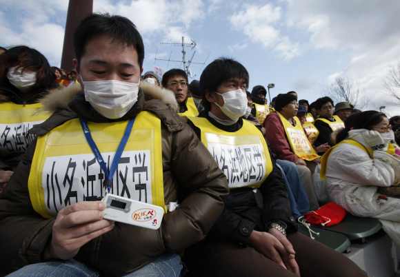 A protester shows his radiation dosimeter as he attends an anti-nuclear rally in Koriyama, Fukushima prefecture
