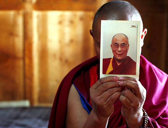 A monk holds a picture of Tibetan spiritual leader Dalai Lama