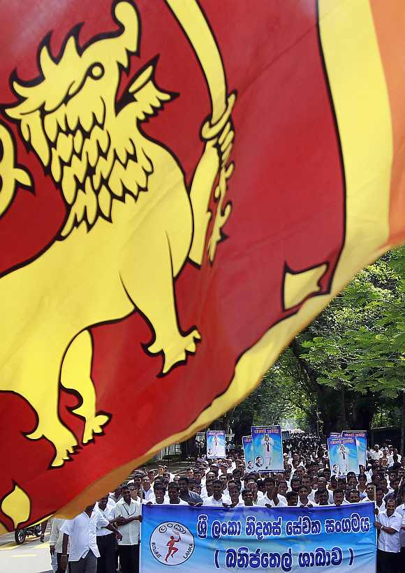 Demonstrators hold up images of the Sri Lanka's president Mahinda Rajapaksa in front of the United Nations head office during a protest in Colombo March 15