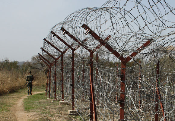 A soldier walks past the electric fencing inside the Line of Control in Jammu & Kashmir.