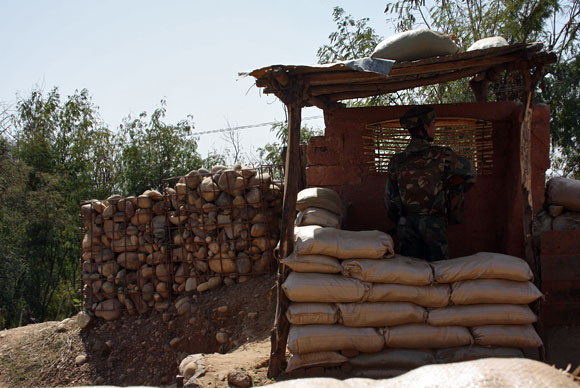A soldier stands his guard, observing the LoC. At some posts, the Pakistani post is less than 70 metres away