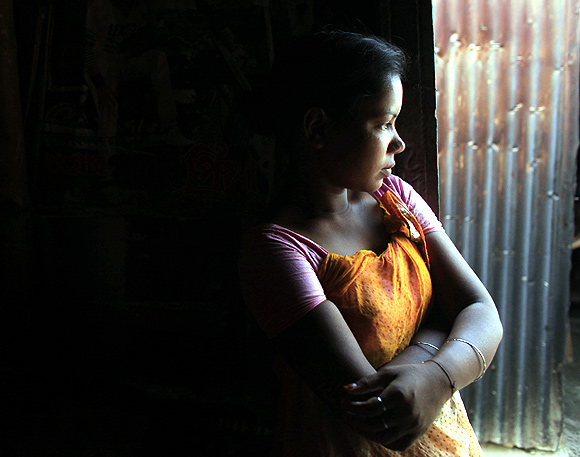 Fourteen-year-old prostitute Lipi waits for customers at a brothel in Faridpur