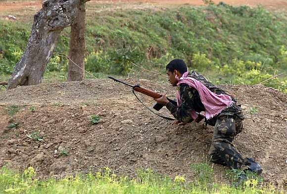 A paramilitary soldier takes up position during a gunfight with Maoist rebels in Pirrakuli village near Lalgarh, in the West Midnapore district, some 170 km of Kolkata