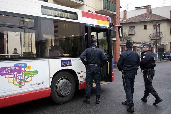 Police enter a city bus which arrives in the neighbourhood to evacuate residents who live in the house where police conduct a raid to arrest suspects in the killings of three children and a rabbi on Monday at a Jewish school, in Toulouse