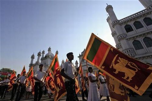 Sri Lankans hold national flags as they march against the UN resolution calling on Sri Lanka to probe wartime human rights abuses, in Colombo