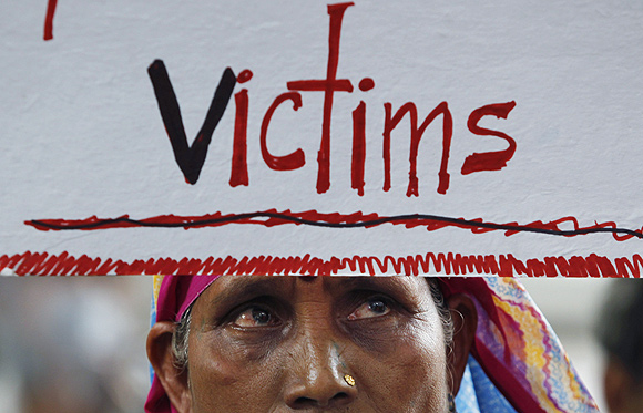 A victim of the 1984 Bhopal gas tragedy holds a placard during a demonstration