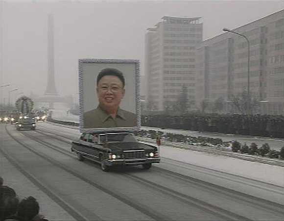 A limousine carrying a portrait of late North Korean leader Kim Jong-il leads his funeral procession past crowds in Pyongyang on December 28, 2011