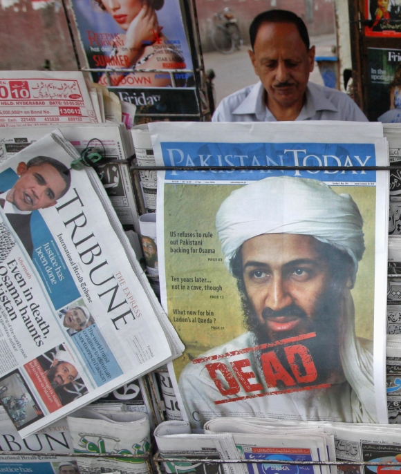 A roadside vendor sells newspapers with headlines about the death of Al Qaeda leader Osama bin Laden in Lahore