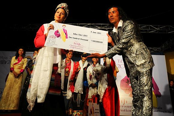 Miss Tibet pageant director Lobsang Wangyal presenting the winners cheque to Tenzin Yangkyi
