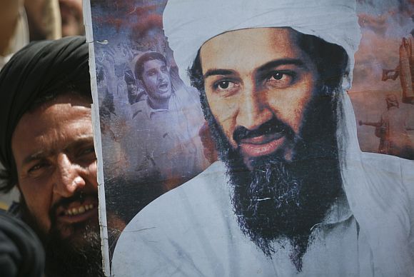 A supporter of the Pakistani religious party Jamiat-e-ulema-e-Islam holds an image of Al Qaeda leader Osama bin Laden during an anti-US rally on the outskirts of Quetta, on May 6, 2011.