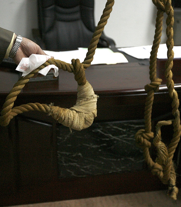 A museum worker shows to reporters a noose that will be displayed in a new Iraqi museum in Baghdad
