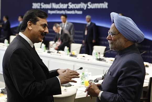 Pakistan's Prime Minister Yousuf Raza Gilani speaks to Prime Minister Manmohan Singh during the Nuclear Security Summit in Seoul