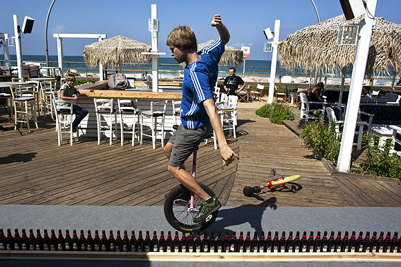 Riding unicycle on beer bottles
