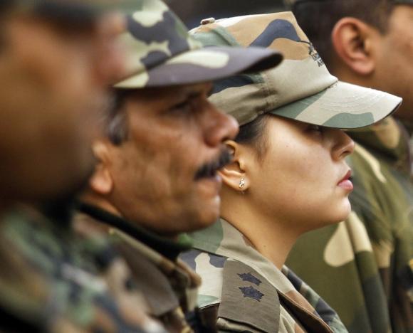 Army officers stand at attention during a wreath-laying ceremony