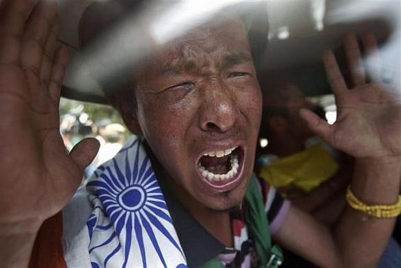 A Tibetan exile shouts slogans inside a car after being detained by police during a protest against the visit of Chinese President Hu Jintao to India, near the venue for the BRICS (Brazil, Russia, India, China and South Africa) Summit in New Delhi