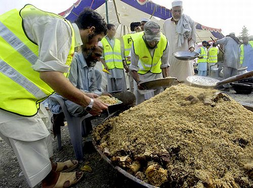 Volunteers of the charity wing of Jamaat-ud-Dawa distribute food to flood survivors