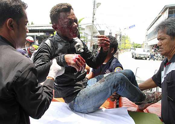 Thai rescue workers help an injured man after a bomb blast in southern Thailand's Yala province