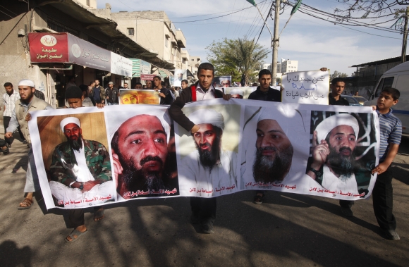 Palestinians hold pictures of Osama bin Laden during a protest against his killing