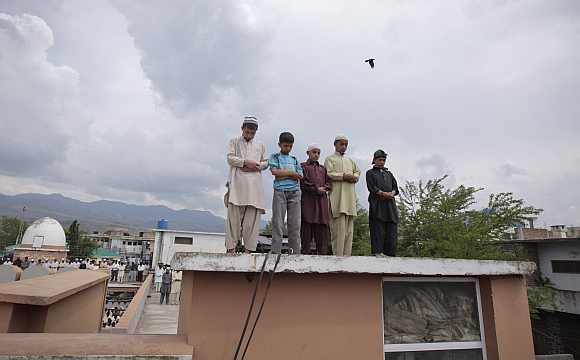 Children offer prayers on the roof of Jamia Masjid Mandian in Abbottabad