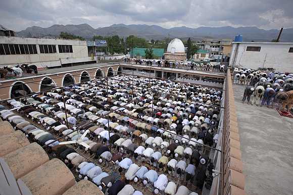 Residents offer prayers in an open yard of the Jamia Masjid Mandian in Abbottabad